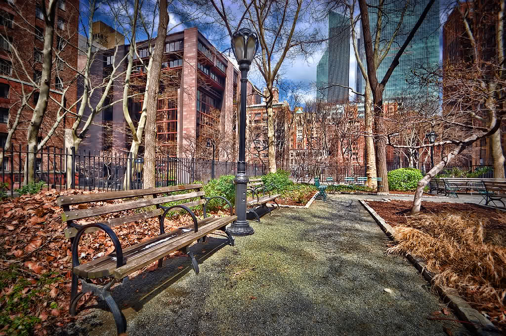 
The Ford Foundation building is off-center to the right, directly behind the Tudor City Greens park sign. The Ford Foundation is a philanthropic organization that funds humanitarian projects worldwide.